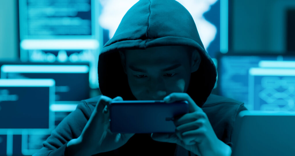 Male hacker using cellphone