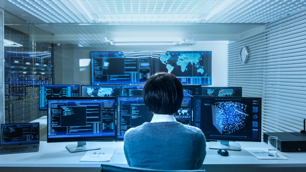 a woman looking at multiple monitors with managed IT services activities